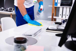 Organized cleaning supplies stored neatly in clear bins on a closet shelf with labeled containers and cloths.